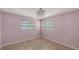 Bright bedroom featuring pink walls, tile floors, a chandelier, and two windows for natural light at 2416 Webber St, Sarasota, FL 34239