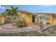 Charming home exterior featuring a brick patio, lush landscaping, and a vibrant yellow facade at 2416 Webber St, Sarasota, FL 34239