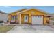 Charming one-story home with a bright yellow exterior, manicured lawn, stamped concrete driveway and cozy front porch at 2416 Webber St, Sarasota, FL 34239