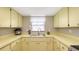 Functional kitchen featuring bright yellow cabinetry, a stainless steel sink, and ample counter space at 2416 Webber St, Sarasota, FL 34239