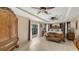 Spacious main bedroom featuring a four-poster bed, ceiling fan, and access to a private patio at 2416 Webber St, Sarasota, FL 34239