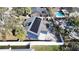 Aerial shot of a home showcases solar panels, fenced yard, and outdoor living spaces at 2900 Woodpine Ct, Sarasota, FL 34231