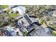 An aerial view of the property with a dark roof, white fence, and an adjacent neighbor with a screened-in pool at 2900 Woodpine Ct, Sarasota, FL 34231