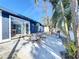 A backyard with a dining table, landscaping, and a sliding glass door at 2900 Woodpine Ct, Sarasota, FL 34231