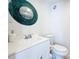 Bathroom featuring white vanity and toilet, framed mirror and a vibrant, round design piece at 2900 Woodpine Ct, Sarasota, FL 34231