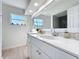 Bright bathroom with a large mirror, white cabinetry, and a view from the window at 2900 Woodpine Ct, Sarasota, FL 34231