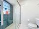 Beautiful bathroom featuring unique blue tiles, a glass-enclosed shower, and modern toilet at 2900 Woodpine Ct, Sarasota, FL 34231
