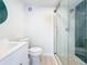 Bright bathroom featuring white vanity, toilet, glass shower and green accent tile at 2900 Woodpine Ct, Sarasota, FL 34231