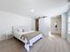 Bright bedroom with white walls, light wood floors and a sliding door leading to a bathroom at 2900 Woodpine Ct, Sarasota, FL 34231