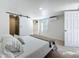 Cozy bedroom with white walls, light wood floors and a sliding door leading to a bathroom at 2900 Woodpine Ct, Sarasota, FL 34231