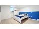 Bedroom featuring white walls, light wood floors, blue accent wall and nautical themed decoration at 2900 Woodpine Ct, Sarasota, FL 34231