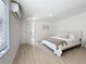 Modern bedroom featuring white walls, light wood floors, a window, and minimalist design at 2900 Woodpine Ct, Sarasota, FL 34231