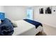 Clean bedroom featuring white walls and light wood floors and a glimpse into another bright room at 2900 Woodpine Ct, Sarasota, FL 34231