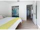 Bright bedroom featuring wood laminate flooring, closet with accent art, and an open doorway at 2900 Woodpine Ct, Sarasota, FL 34231