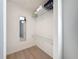 Walk-in closet with white wire shelving and light wood floors and a view into a bathroom at 2900 Woodpine Ct, Sarasota, FL 34231