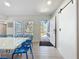 The dining room is bright with an open doorway, featuring wood floors, and a white table with blue chairs at 2900 Woodpine Ct, Sarasota, FL 34231