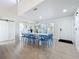 Spacious dining area with a large white table, light wood floors, and white interior at 2900 Woodpine Ct, Sarasota, FL 34231