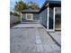 Exterior view of a navy blue home with a white fence, grey pavers, and a gravel yard at 2900 Woodpine Ct, Sarasota, FL 34231