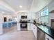 Modern kitchen featuring stainless steel appliances, white cabinets, and a view to the dining area at 2900 Woodpine Ct, Sarasota, FL 34231