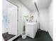 Well-lit laundry room with door to outside and full size washer and dryer at 2900 Woodpine Ct, Sarasota, FL 34231