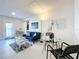 Bright living room with stylish furniture, including a plush blue sofa and a glass table at 2900 Woodpine Ct, Sarasota, FL 34231