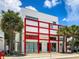 Modern exterior design with eye-catching red accents and inviting street presence, surrounded by lush palm trees at 430 Kumquat Ct # 406, Sarasota, FL 34236