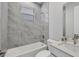 Bathroom features a tub and shower combination with gray marble tile and a single sink vanity at 4529 Crowell Ln, North Port, FL 34288