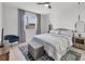 Bright bedroom features neutral tones, a large window, a ceiling fan, and stylish decor at 4529 Crowell Ln, North Port, FL 34288