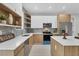 A spacious kitchen with an island, a dishwasher, stainless steel appliances, and wood shelving at 4529 Crowell Ln, North Port, FL 34288