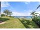 Waterfront property boasts lush lawn with a private wooden dock extending into the serene bay waters at 4620 Riverview Blvd, Bradenton, FL 34209