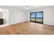Bright bedroom with hardwood floors, a ceiling fan, ensuite bathroom and sliding glass doors to an outdoor balcony at 4620 Riverview Blvd, Bradenton, FL 34209