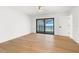 Bright bedroom with hardwood floors, ceiling fan, sliding glass door to a balcony and an ensuite bathroom at 4620 Riverview Blvd, Bradenton, FL 34209