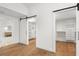 Hallway with closet and bathroom access featuring hardwood floors, white walls, and black hardware at 4620 Riverview Blvd, Bradenton, FL 34209