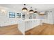Modern kitchen with white cabinets, a large island, and hardwood floors at 4620 Riverview Blvd, Bradenton, FL 34209