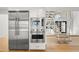 Stainless steel appliances, white cabinets, hardwood floors and modern staircase at 4620 Riverview Blvd, Bradenton, FL 34209