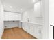Laundry room with lots of storage, hardwood floors, and white cabinets at 4620 Riverview Blvd, Bradenton, FL 34209