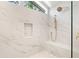 This stylish shower features white marble tile, a shower bench, and upscale bronze fixtures at 4620 Riverview Blvd, Bradenton, FL 34209