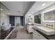 Bathroom featuring double sink vanity, a bathtub, a dark gray wall, and a window for plenty of light at 5236 Siesta Cove Dr, Sarasota, FL 34242