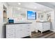 Bright bathroom featuring dual vanities, textured wall tiles, and sleek fixtures at 5236 Siesta Cove Dr, Sarasota, FL 34242