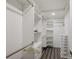 Walk-in closet with white shelving and dark laminate floors at 5236 Siesta Cove Dr, Sarasota, FL 34242