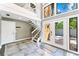 Bright foyer with elegant staircase, tile flooring and modern design accents at 5236 Siesta Cove Dr, Sarasota, FL 34242