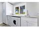 Well-lit laundry room boasts ample counter space, storage cabinets, and a picturesque window view at 5236 Siesta Cove Dr, Sarasota, FL 34242