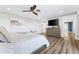 Spacious main bedroom with wood floors, ceiling fan, and a television on top of a wood dresser at 5236 Siesta Cove Dr, Sarasota, FL 34242