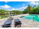 Waterfront home features a pristine pool, fire pit, and lounge chairs for serene relaxation by the water at 5236 Siesta Cove Dr, Sarasota, FL 34242