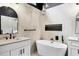 Modern bathroom featuring a sleek soaking tub, minimalist fixtures, and elegant marble-style tile surround at 6409 Stone River Rd, Bradenton, FL 34203