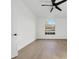 Well-lit bedroom showcasing light wood floors, a ceiling fan, and a large arched window with a neighborhood view at 6409 Stone River Rd, Bradenton, FL 34203