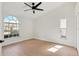 Bright bedroom features light wood floors, a ceiling fan, and a large arched window offering scenic neighborhood views at 6409 Stone River Rd, Bradenton, FL 34203