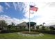 Clubhouse exterior showcasing manicured landscaping, an American flag, and entrance at 6409 Stone River Rd, Bradenton, FL 34203