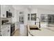 Well-lit kitchen with an island and stainless steel appliances leads to an outdoor screened-in patio at 6409 Stone River Rd, Bradenton, FL 34203