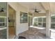 Screened-in patio featuring brick flooring, ceiling fans, and access to the kitchen at 6409 Stone River Rd, Bradenton, FL 34203
